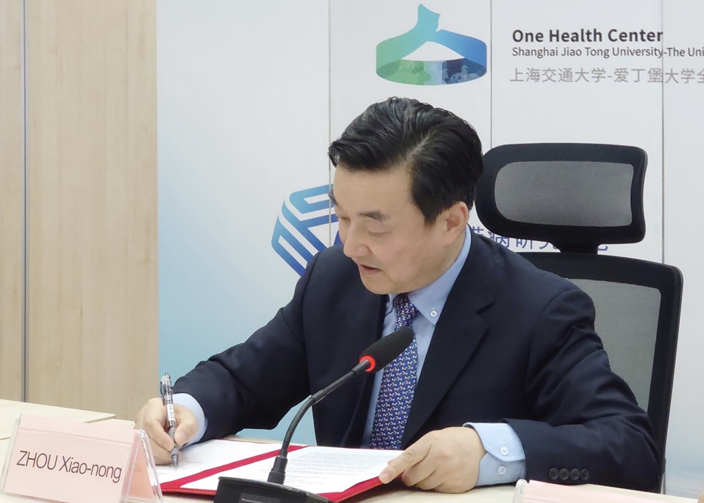 桌子前坐着穿西装打领带的男子中度可信度描述已自动生成